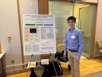 Charlie Herz standing by his project, "The Structure of Freedom: Formal Consensus and Information Exchange in USENET and Wikipedia."